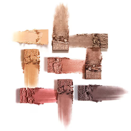 Collection of crushed makeup powders in various shades on a white background